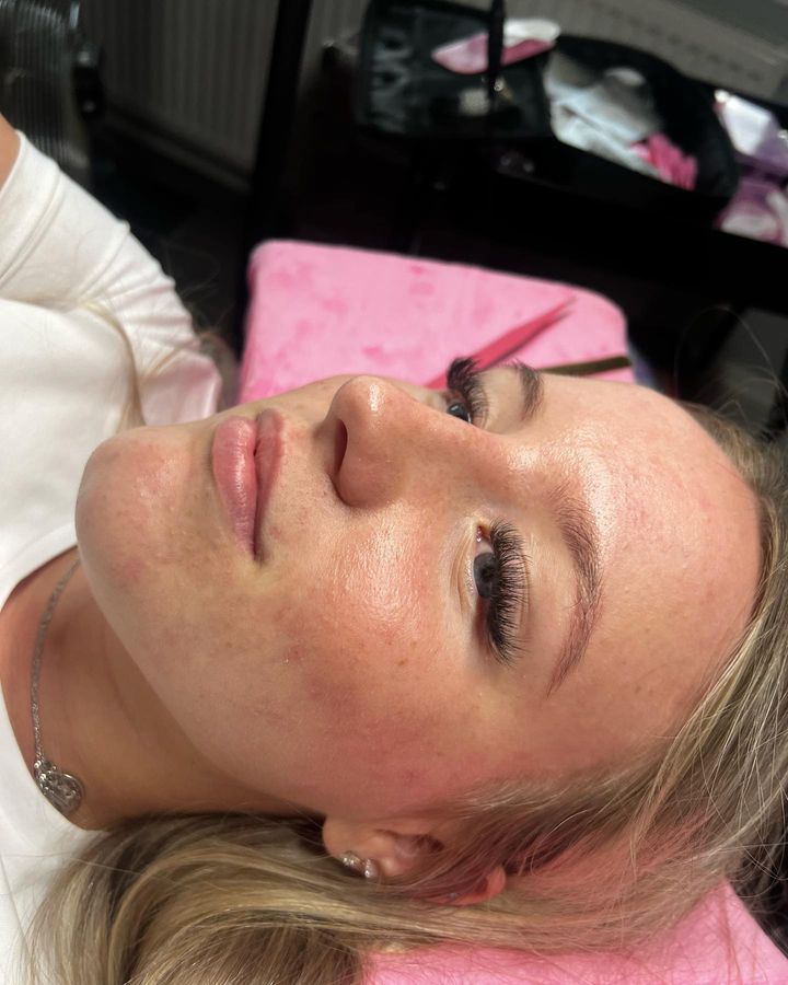 Eyelash extension application on a woman in salon.